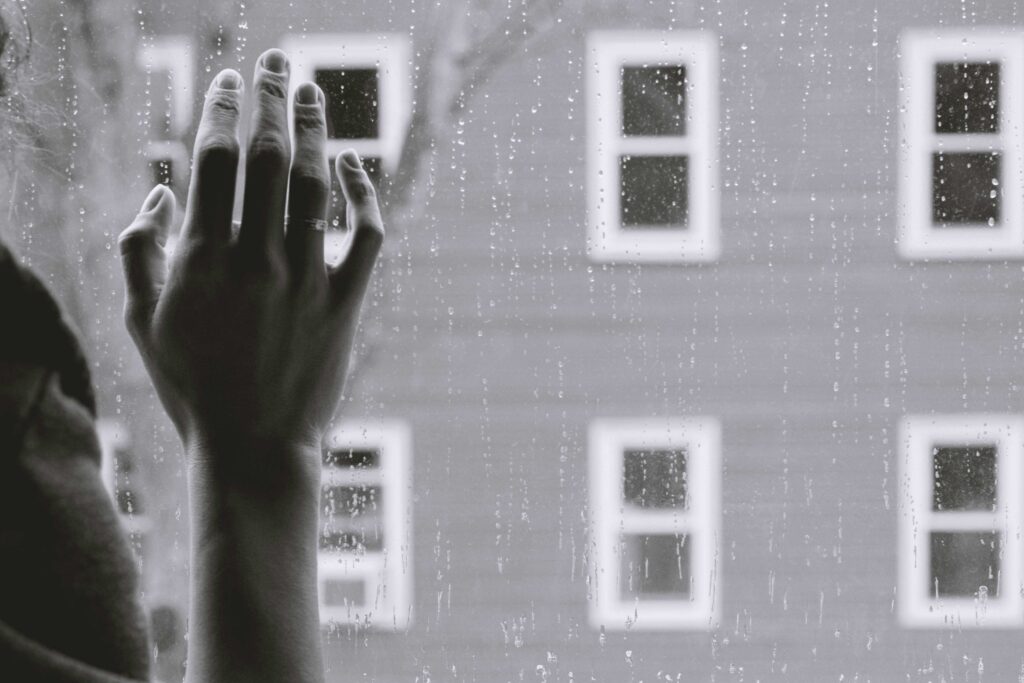 Ladies hand touching a window, a lonely scene.